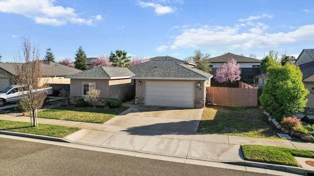 view of front of home featuring stucco siding, an attached garage, fence, stone siding, and driveway