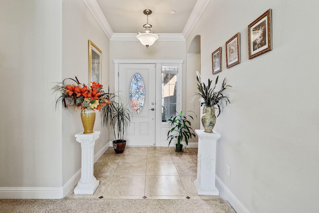 entrance foyer featuring baseboards, arched walkways, and ornamental molding