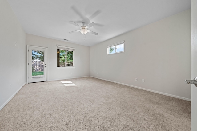 carpeted spare room with plenty of natural light, visible vents, and baseboards