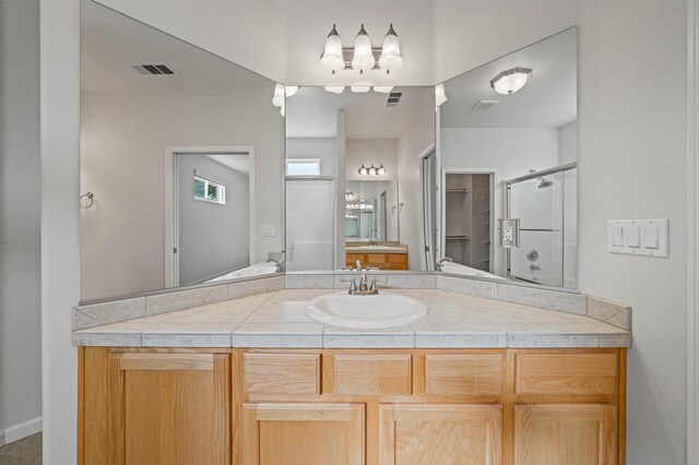 full bathroom with a stall shower, visible vents, and vanity