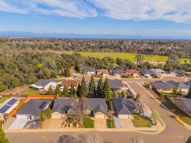 birds eye view of property featuring a mountain view, a wooded view, and a residential view