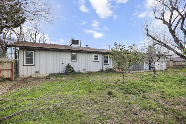 back of property with crawl space, fence, central air condition unit, and a lawn