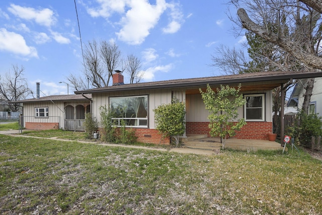 ranch-style house featuring brick siding, a chimney, fence, board and batten siding, and a front yard