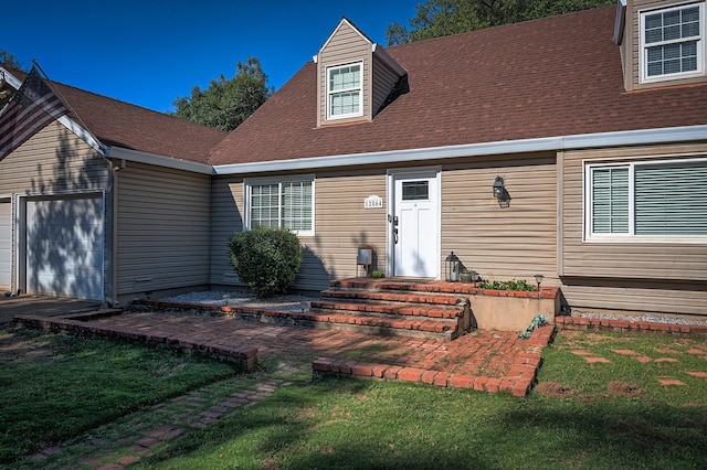 view of front of home with an attached garage and a shingled roof