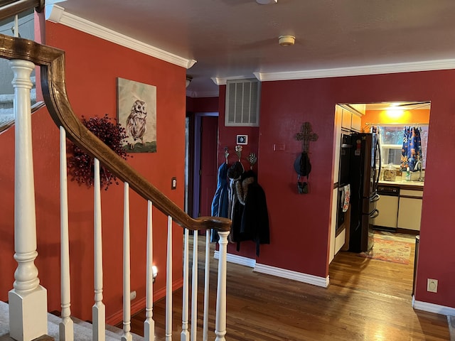 interior space featuring ornamental molding, wood finished floors, visible vents, and baseboards