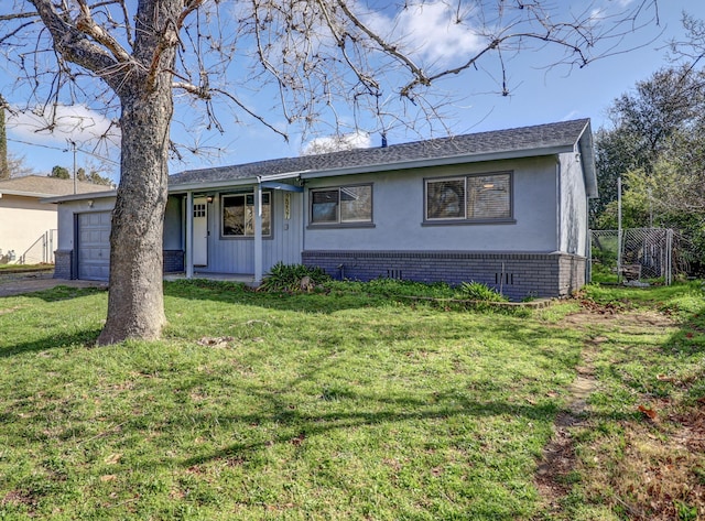 ranch-style home with brick siding, stucco siding, fence, a garage, and a front lawn