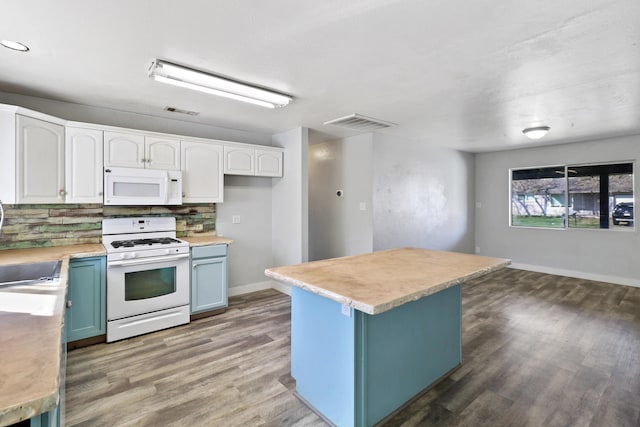 kitchen with white appliances, visible vents, decorative backsplash, wood finished floors, and blue cabinetry