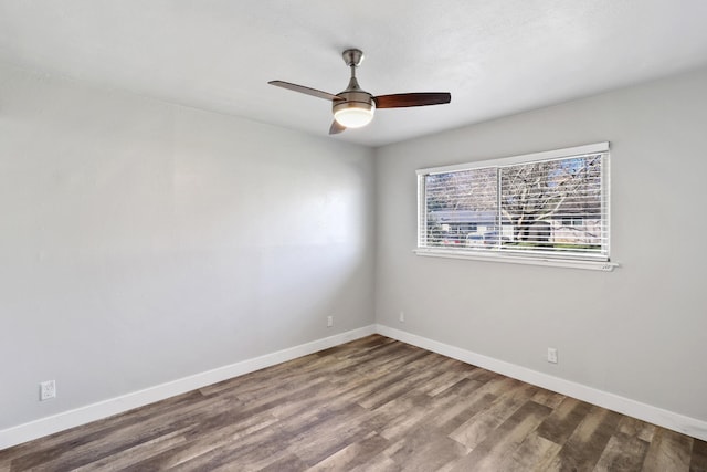 spare room featuring a ceiling fan, baseboards, and wood finished floors