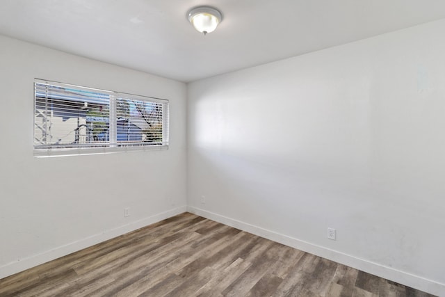 unfurnished room with wood finished floors and baseboards