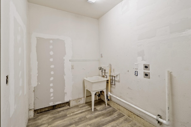 laundry area with laundry area, washer hookup, and wood finished floors