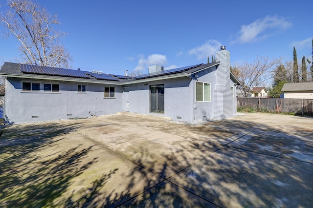 back of house featuring a chimney, crawl space, a patio area, and a fenced backyard