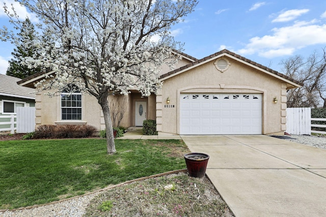 view of front of house featuring an attached garage, fence, and stucco siding