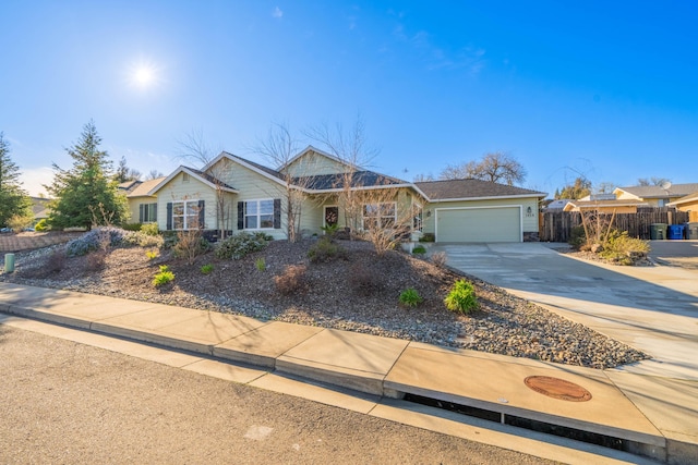 ranch-style house featuring a garage, concrete driveway, and fence