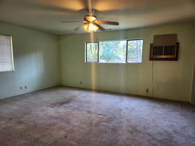 spare room featuring a ceiling fan, a wall mounted air conditioner, and carpet flooring