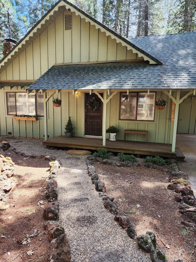 view of front of property featuring covered porch, board and batten siding, and roof with shingles