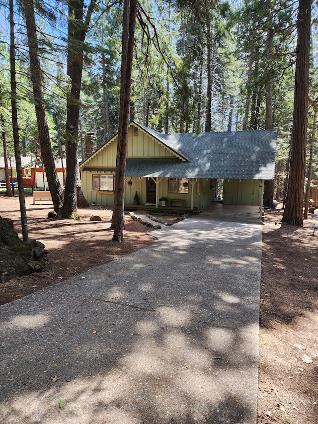 view of front of house featuring aphalt driveway, board and batten siding, and roof with shingles