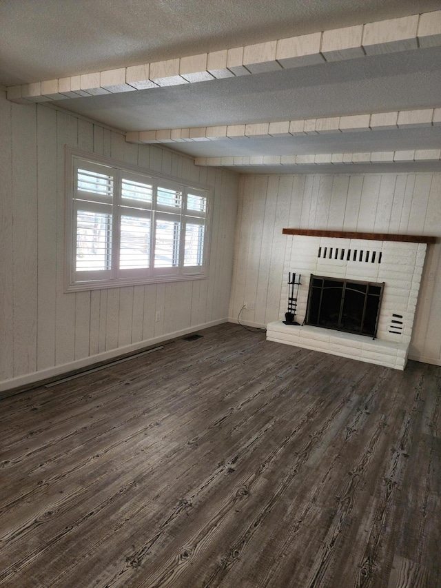 unfurnished living room featuring dark wood-type flooring, a fireplace, visible vents, and baseboards