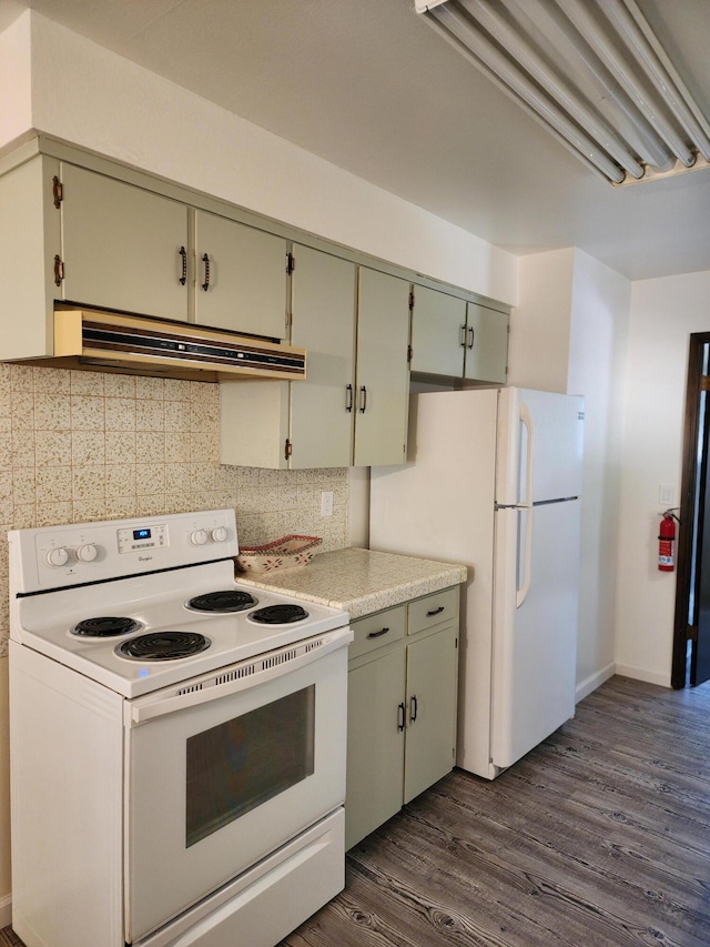 kitchen with under cabinet range hood, white appliances, dark wood-style flooring, light countertops, and tasteful backsplash