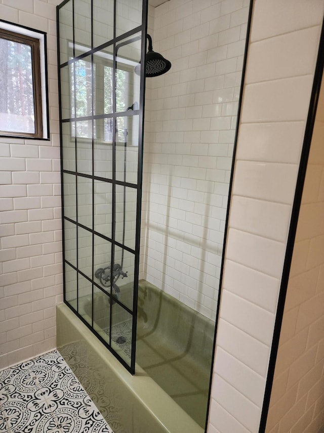 bathroom with tile patterned flooring and bath / shower combo with glass door