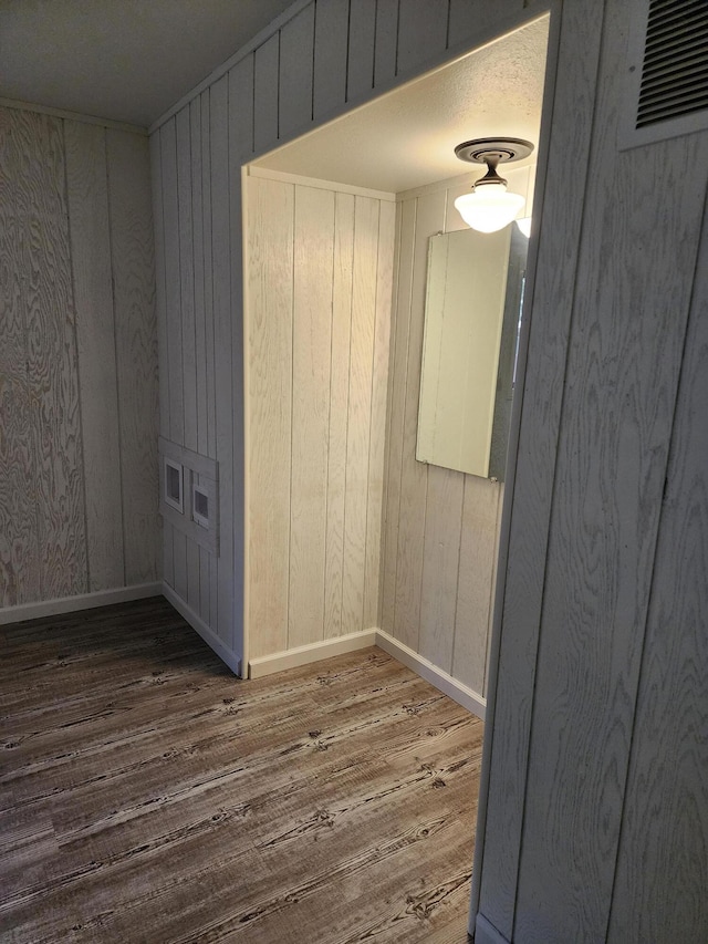 empty room featuring baseboards, visible vents, and wood finished floors