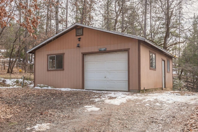 snow covered garage featuring a garage