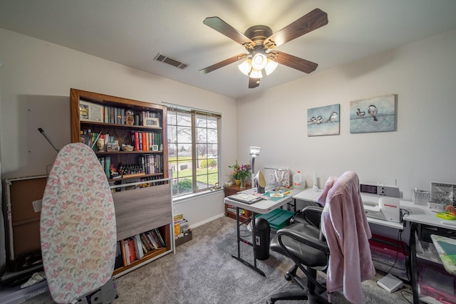 office space with visible vents, baseboards, carpet flooring, and a ceiling fan