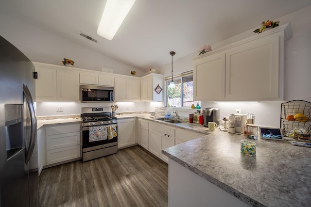 kitchen with visible vents, vaulted ceiling, dark wood-style floors, stainless steel appliances, and a sink