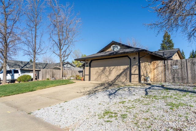 garage with driveway and fence