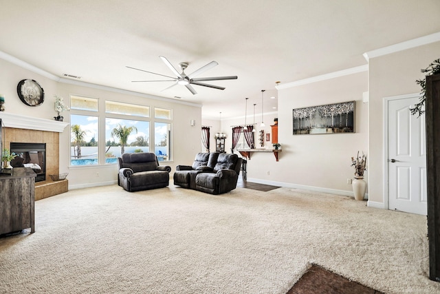 living area with baseboards, visible vents, a fireplace, crown molding, and carpet flooring