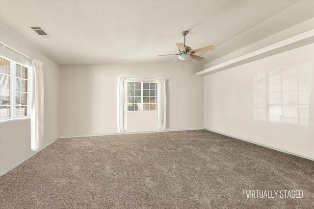 unfurnished room featuring lofted ceiling, carpet, a healthy amount of sunlight, and visible vents