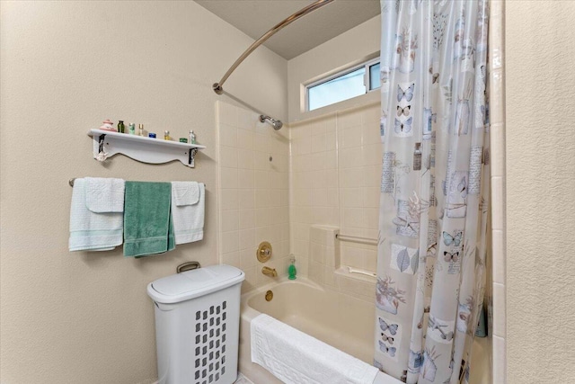 bathroom with shower / bath combo and a textured wall