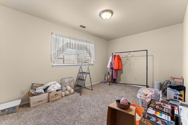 playroom featuring baseboards, a textured ceiling, visible vents, and carpet flooring