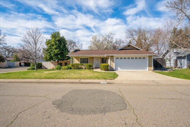 single story home featuring a garage, concrete driveway, a front lawn, and fence