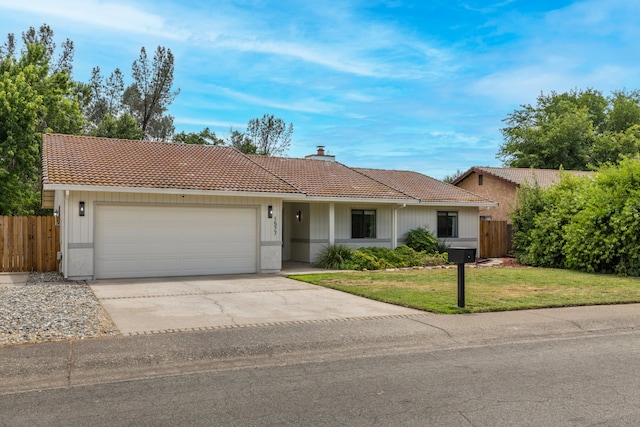 ranch-style home with a front lawn, an attached garage, a tile roof, and fence