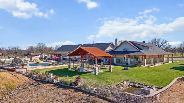 exterior space with a patio, a chimney, a lawn, and a gazebo