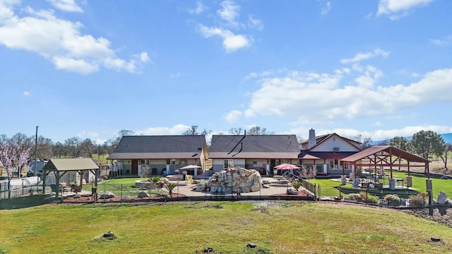 back of property featuring a lawn, fence, a gazebo, and a patio