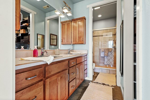 bathroom with visible vents, a sink, a shower stall, and toilet