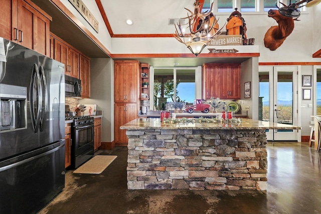 kitchen featuring finished concrete flooring, black appliances, tasteful backsplash, and brown cabinetry