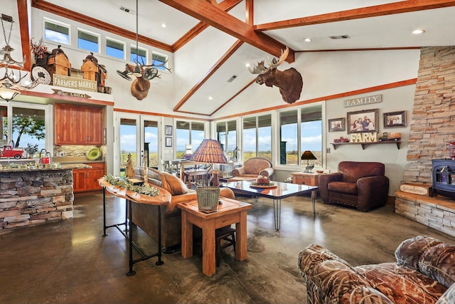 living room featuring visible vents, high vaulted ceiling, a wood stove, and finished concrete floors