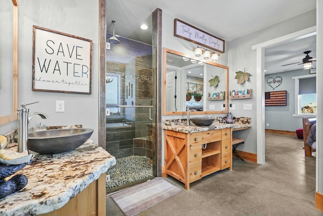 ensuite bathroom with ceiling fan, concrete floors, vanity, baseboards, and a shower stall