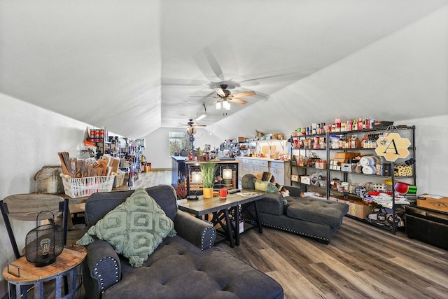 living area featuring vaulted ceiling, ceiling fan, and wood finished floors