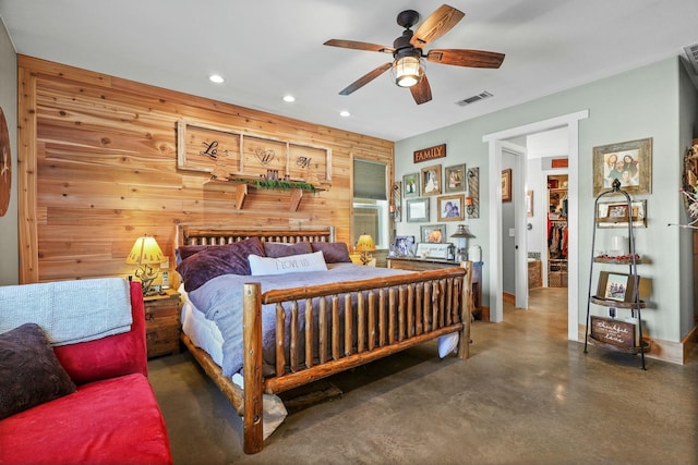 bedroom featuring recessed lighting, wood walls, a ceiling fan, visible vents, and finished concrete floors