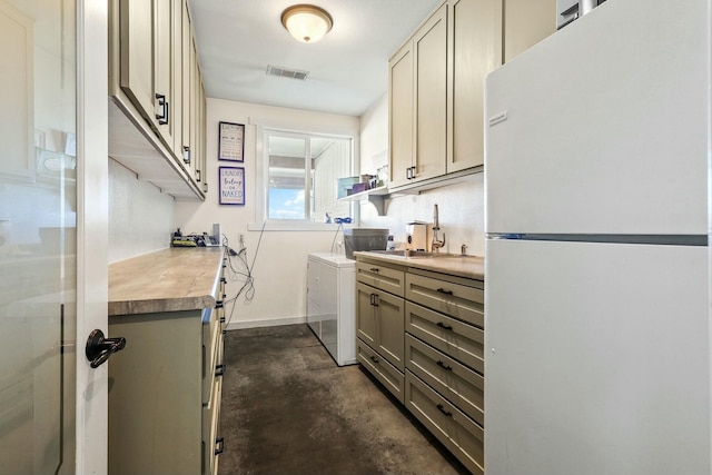 kitchen with gray cabinetry, concrete floors, a sink, visible vents, and freestanding refrigerator