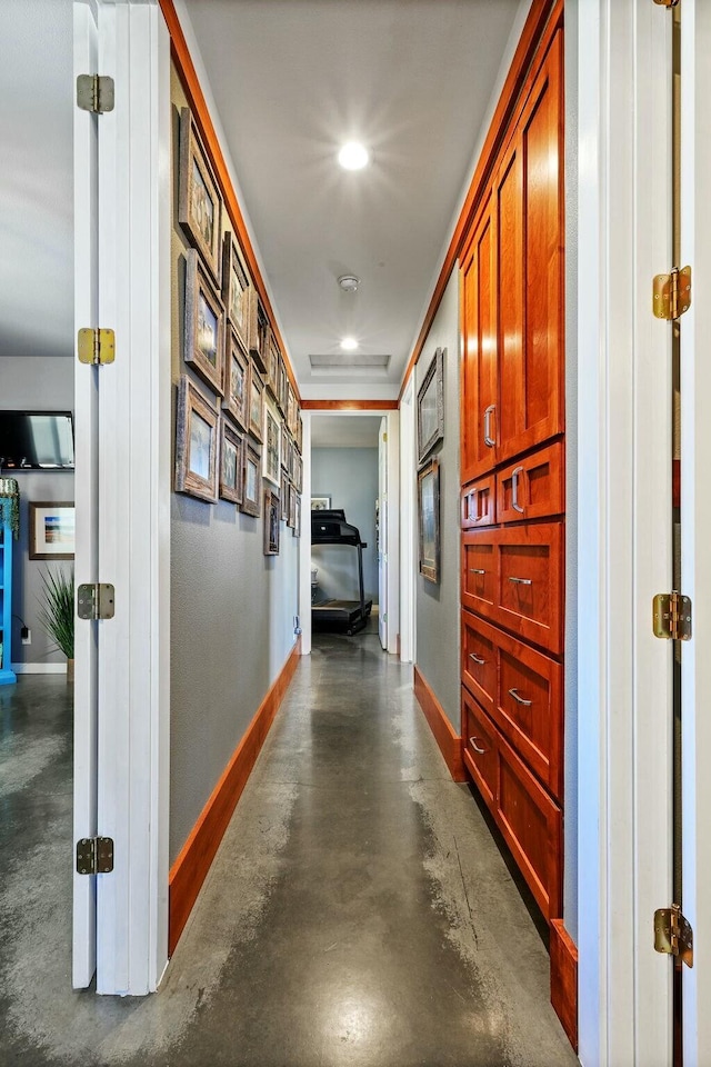 hallway featuring recessed lighting, concrete floors, and baseboards