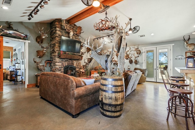 living area featuring vaulted ceiling with beams, a fireplace, visible vents, and concrete flooring