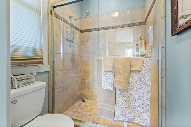 bathroom with a shower stall and toilet