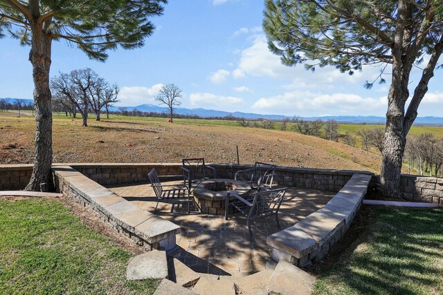 view of yard with a patio, an outdoor fire pit, and a rural view