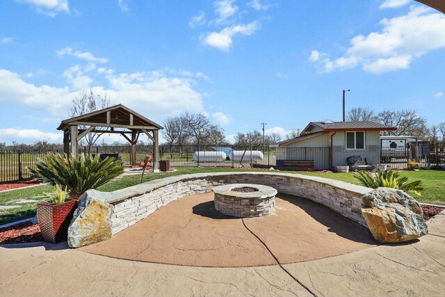 view of patio / terrace with fence, a fire pit, and a gazebo