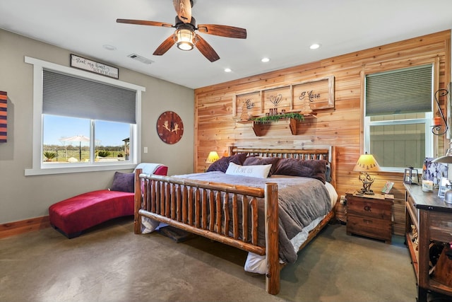 bedroom with baseboards, visible vents, concrete flooring, wood walls, and recessed lighting