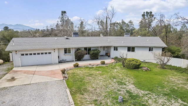 ranch-style house featuring a garage, concrete driveway, a shingled roof, and a front lawn